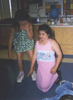 The photograph shows two students dramatizing the rising sun.
