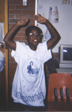 The photograph shows a child dramatizing the sun.