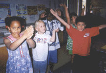 The photograph shows children dramatizing erupting volcanoes.